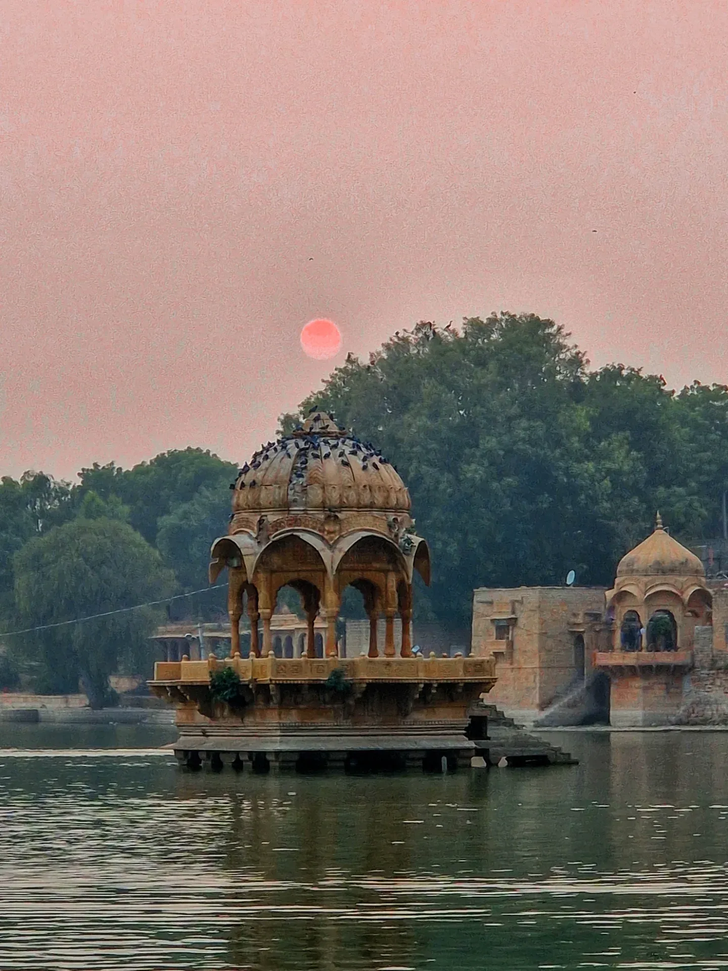 Carved stone pavilion beside calm waters near Jaisalmer