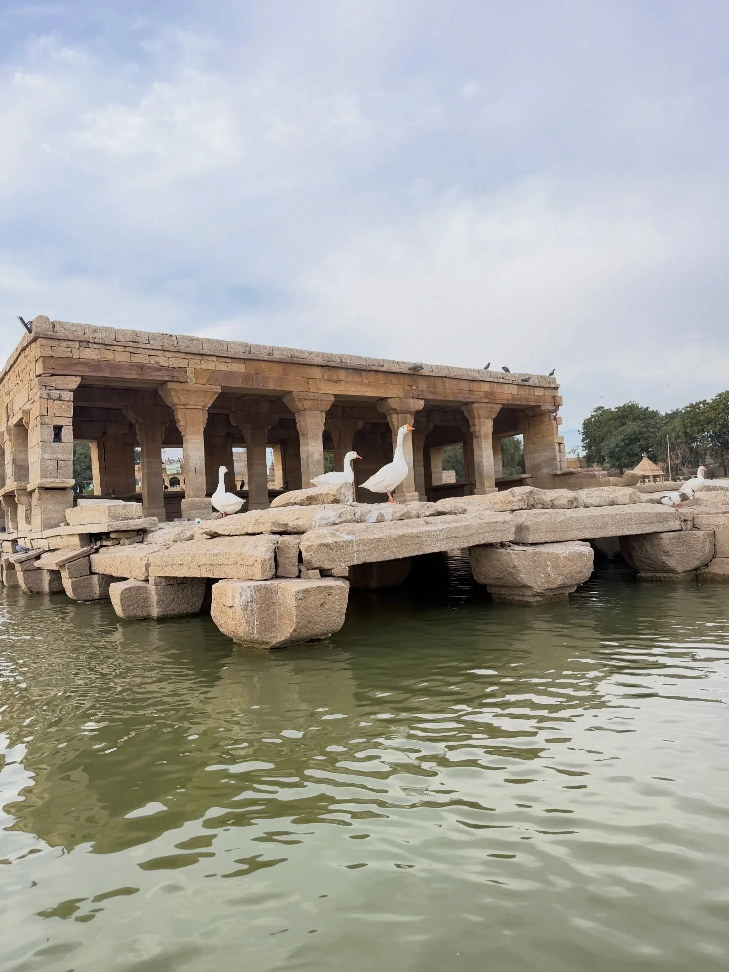 Golden stone arches and peaceful waters at dusk in Jaisalmer